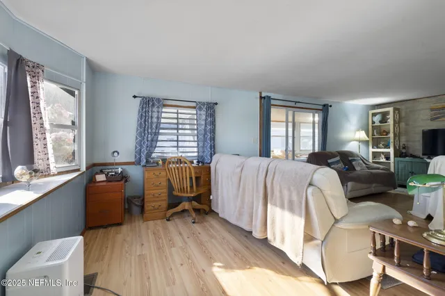 a bedroom with a bed and wooden floor