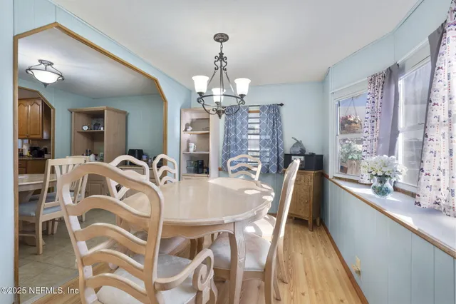 a view of a dining room with furniture and a chandelier