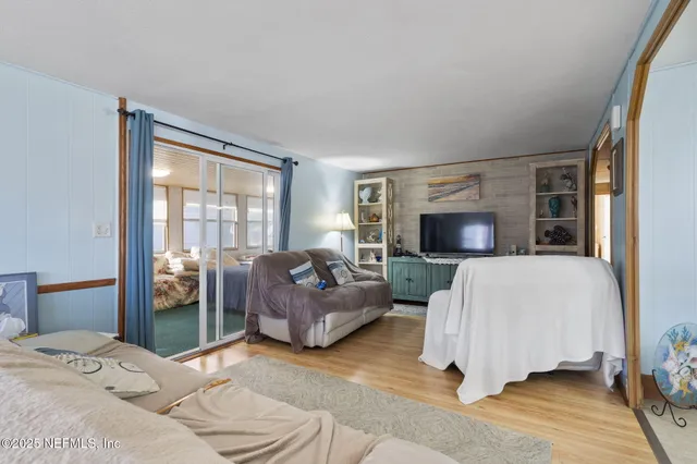 a bedroom with a bed couches and a flat tv screen