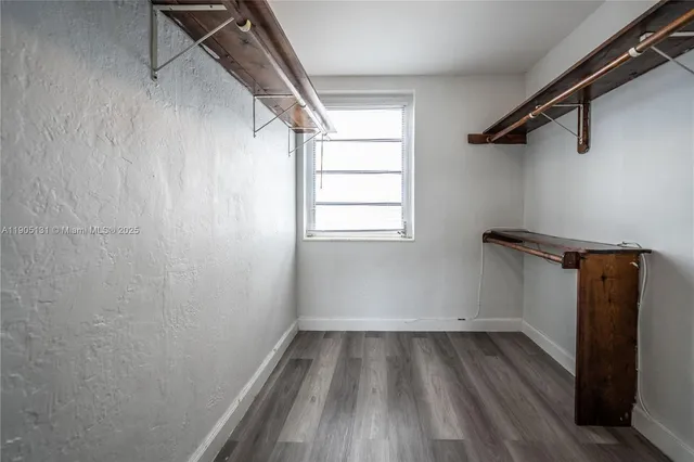 a view of a room with wooden floor and small window