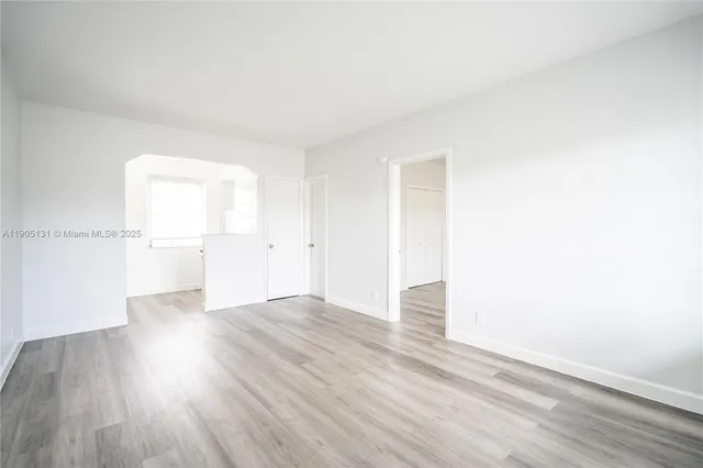 an empty room with wooden floor and a window