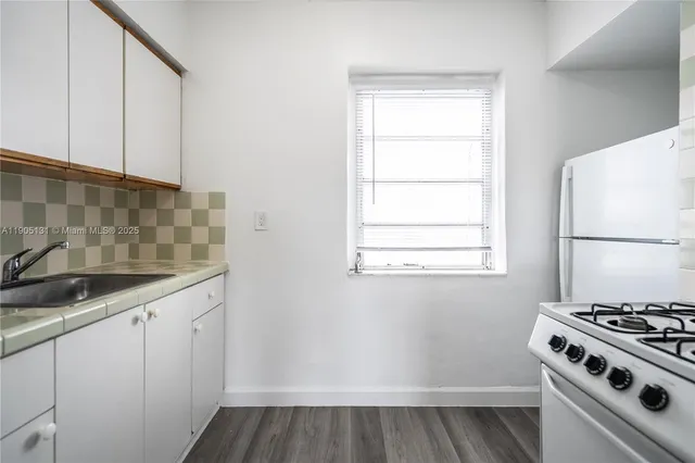 a kitchen with a sink a stove and cabinets