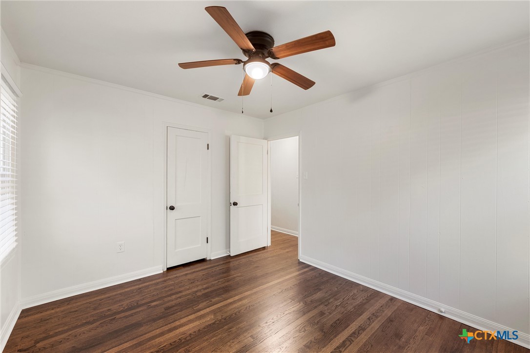 1203 South 5th Street Temple, TX 76504 - Photo 13 of 20 an empty room with wooden floor ceiling fan and window