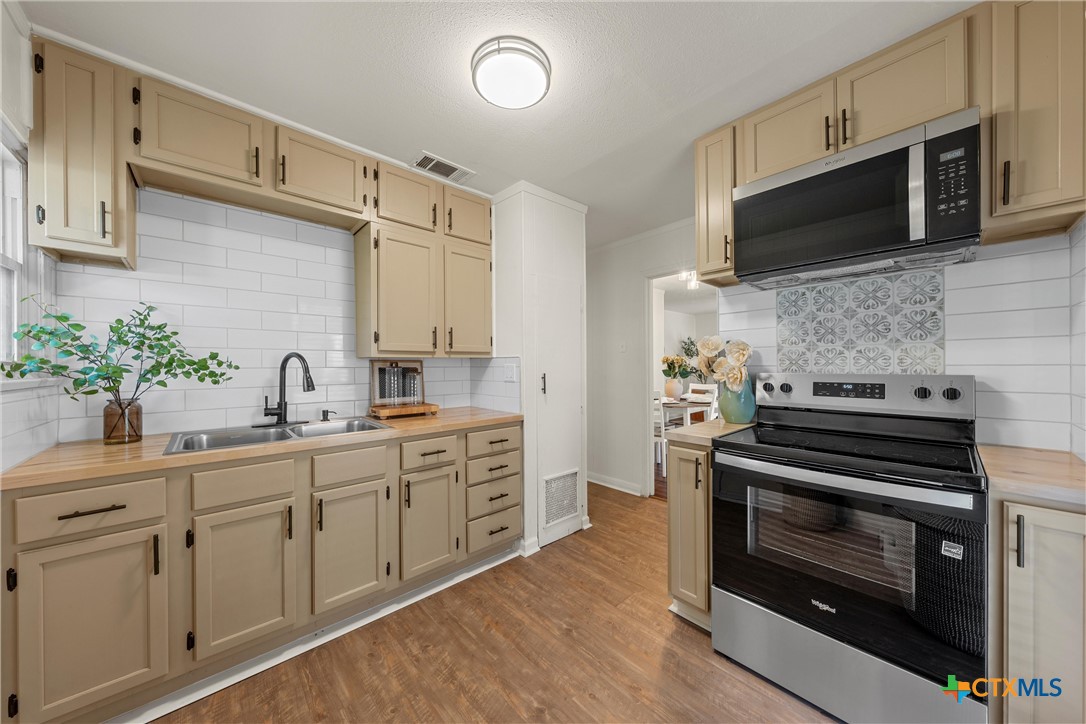 1203 South 5th Street Temple, TX 76504 - Photo 5 of 18 a kitchen with stainless steel appliances a stove microwave and cabinets