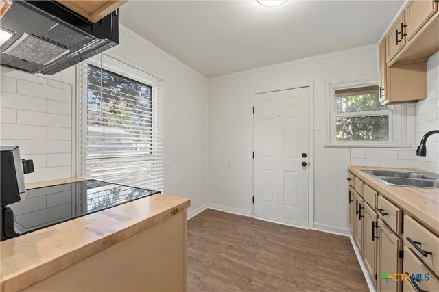 a kitchen with stainless steel appliances a stove microwave and sink