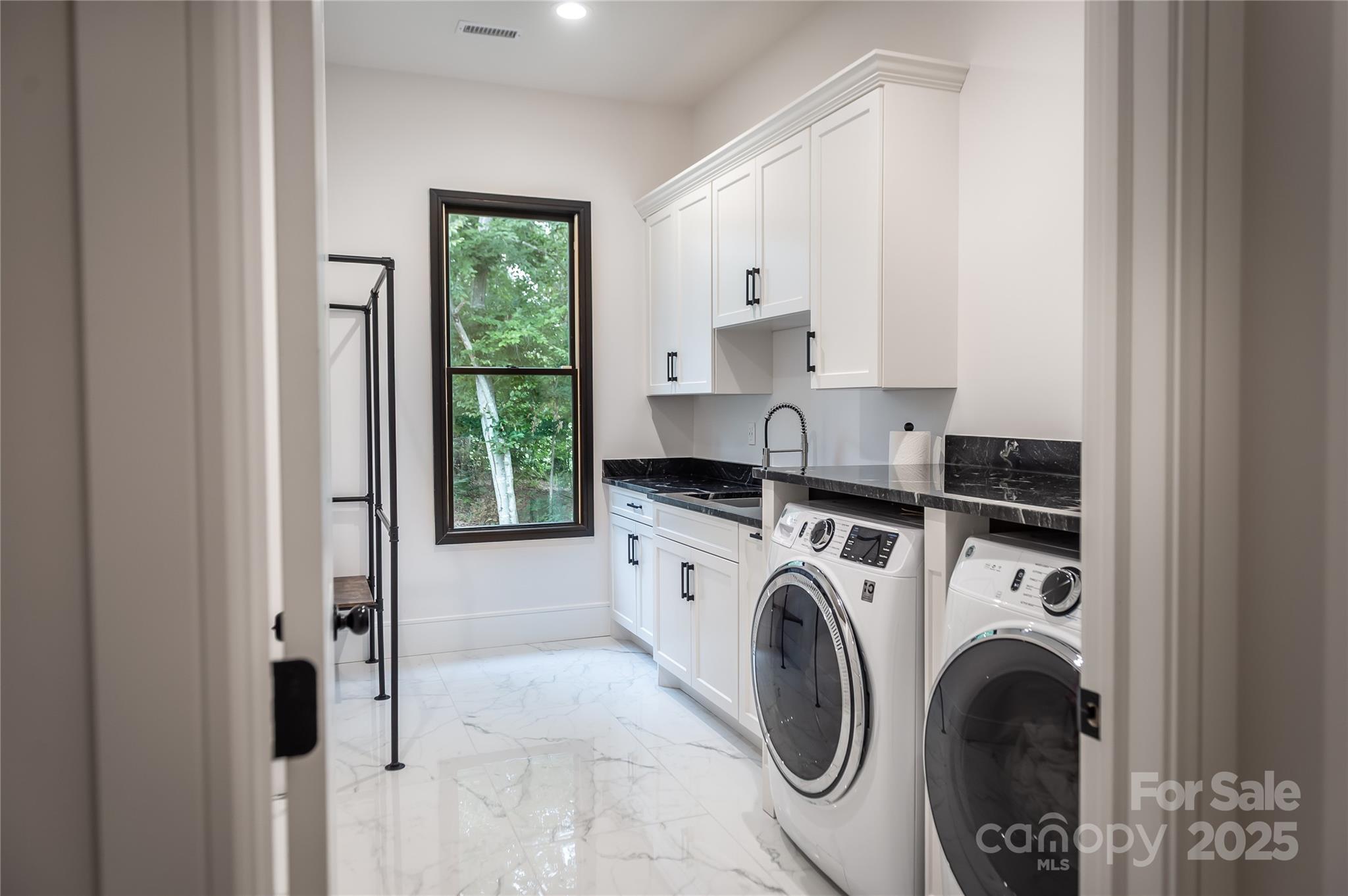 668 Players Ridge Road Hickory, NC 28601 - Photo 32 of 48 a view of washer and dryer with kitchen in the background