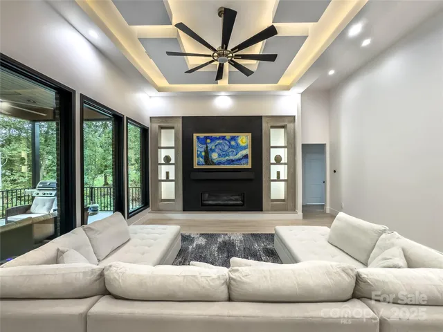 a living room with furniture ceiling fan and a large window