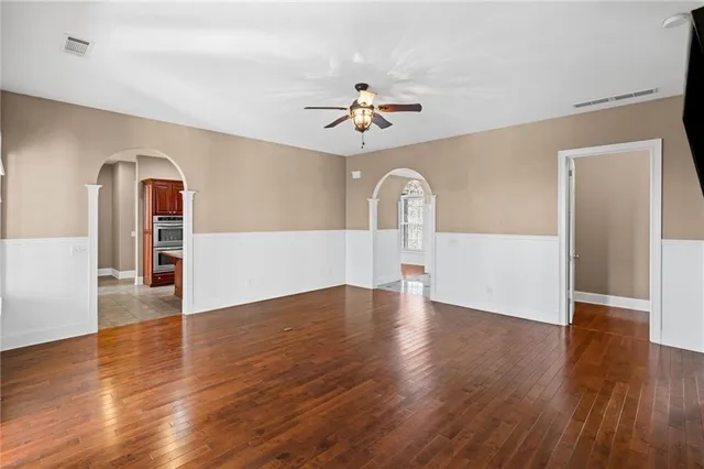 a view of a livingroom with wooden floor and a ceiling fan