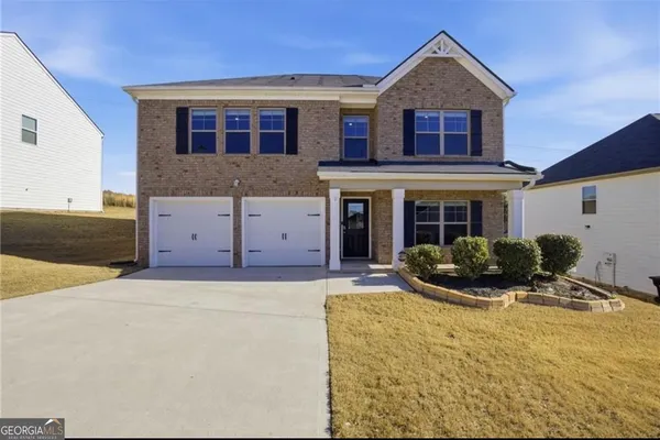 a front view of a house with yard and parking space