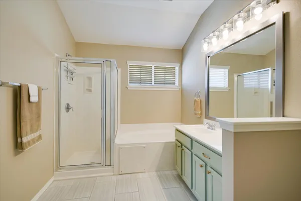 a bathroom with a tub sink and mirror