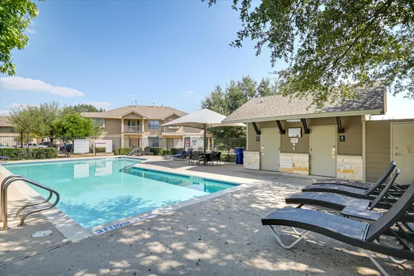 a patio with a table and chairs under an umbrella