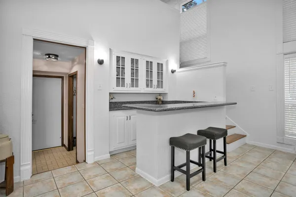 a kitchen with cabinets and chairs