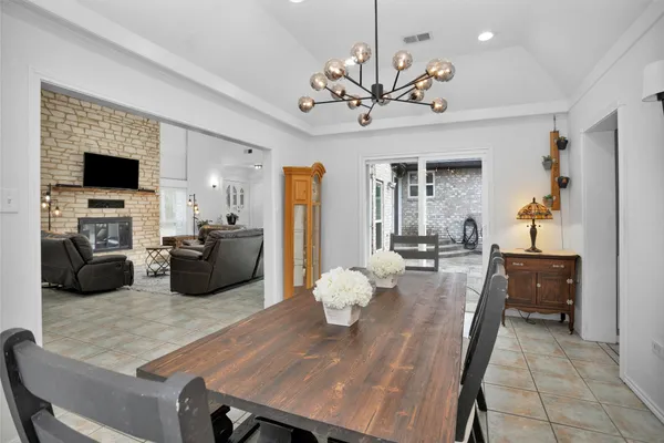 a living room with furniture a chandelier and a flat screen tv