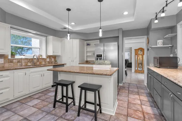a kitchen with granite countertop a sink appliances counter top space and cabinets