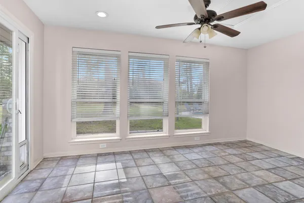 a view of an empty room with a window and a ceiling fan