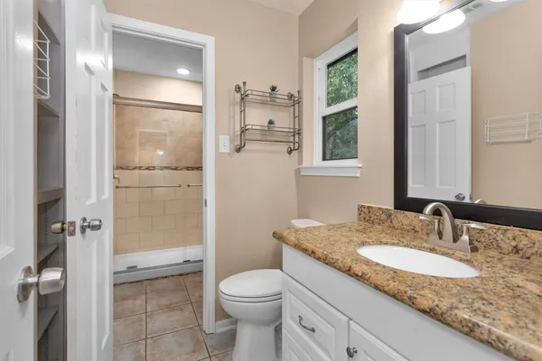 a bathroom with a granite countertop sink toilet and shower