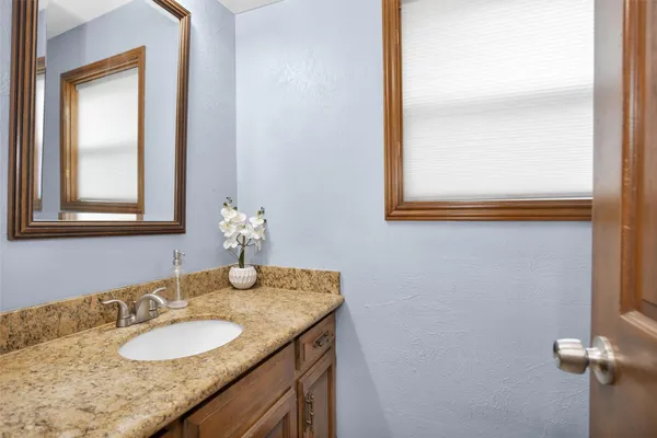 a bathroom with a granite countertop sink and a mirror