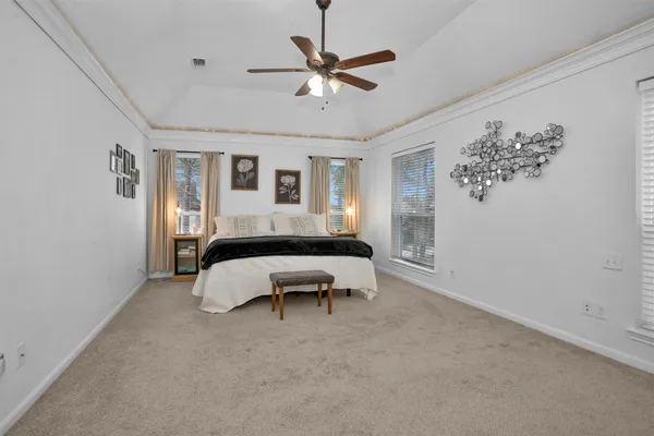 a spacious bedroom that has a bed and a table in it