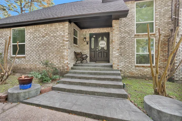 a view of a door of the house with outdoor seating and plants