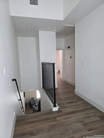 a view of a hallway with wooden floor