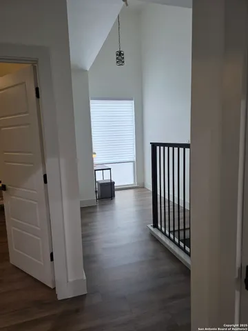 an empty room with wooden floor and entrance