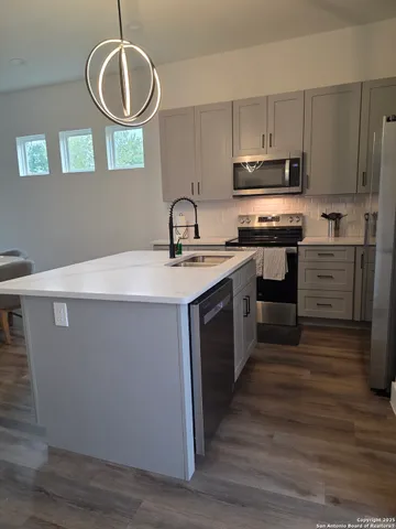 a kitchen with a refrigerator and wooden floor