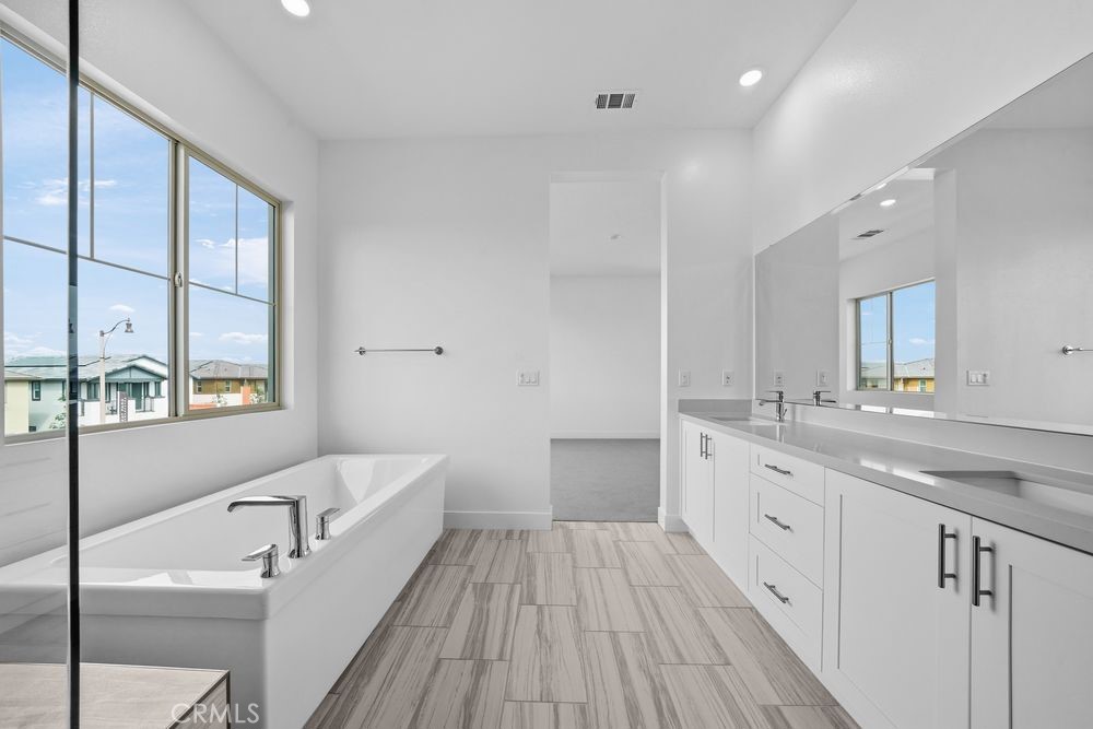 118 Pansy Irvine, CA 92618 - Photo 19 of 46 a bathroom with a granite countertop sink a large mirror and a bathtub