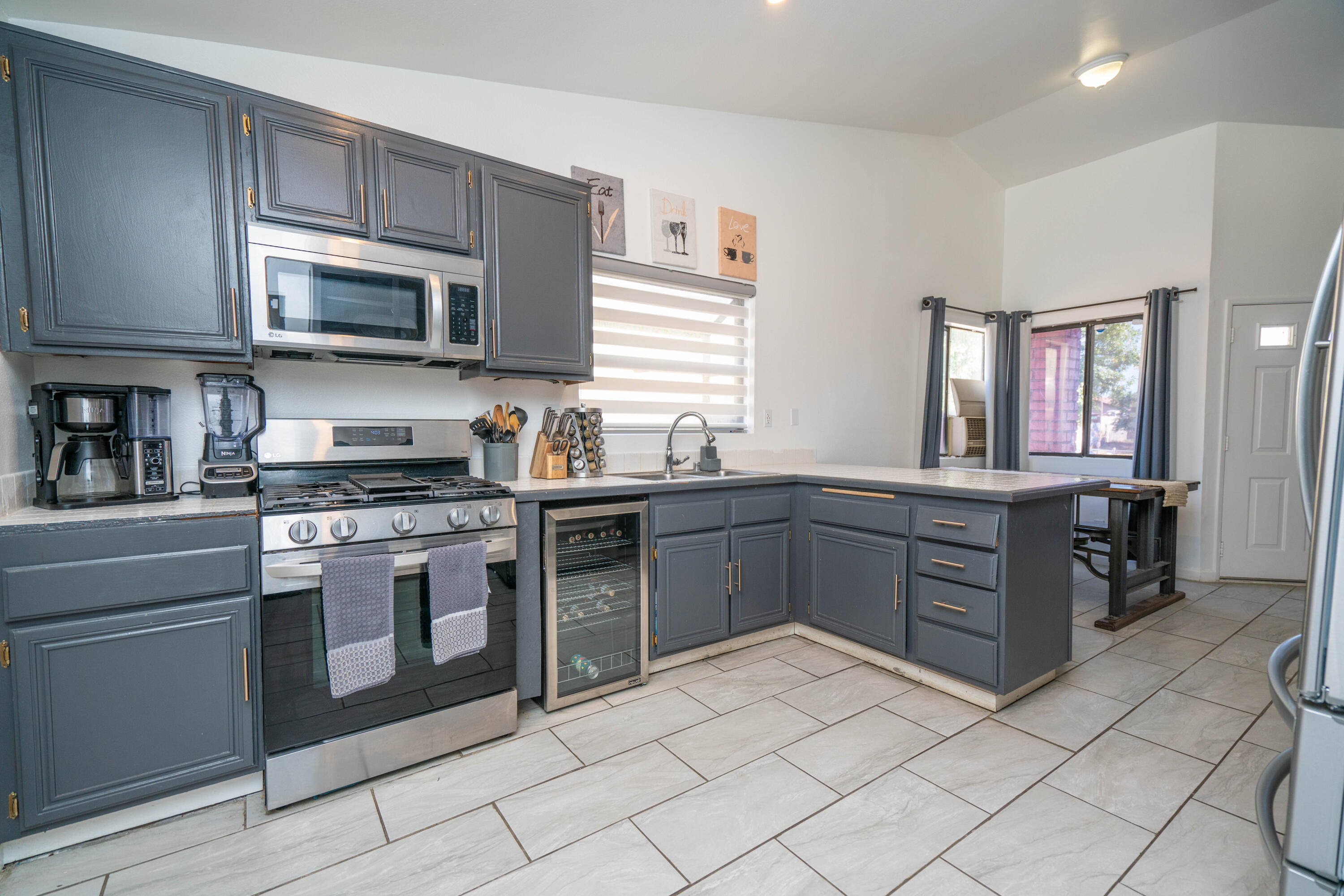 419 Quandt Ranch Road San Jacinto, CA 92583 - Photo 10 of 40 a kitchen with stainless steel appliances granite countertop a stove top oven a sink dishwasher and a microwave oven on the blue kitchen countertops