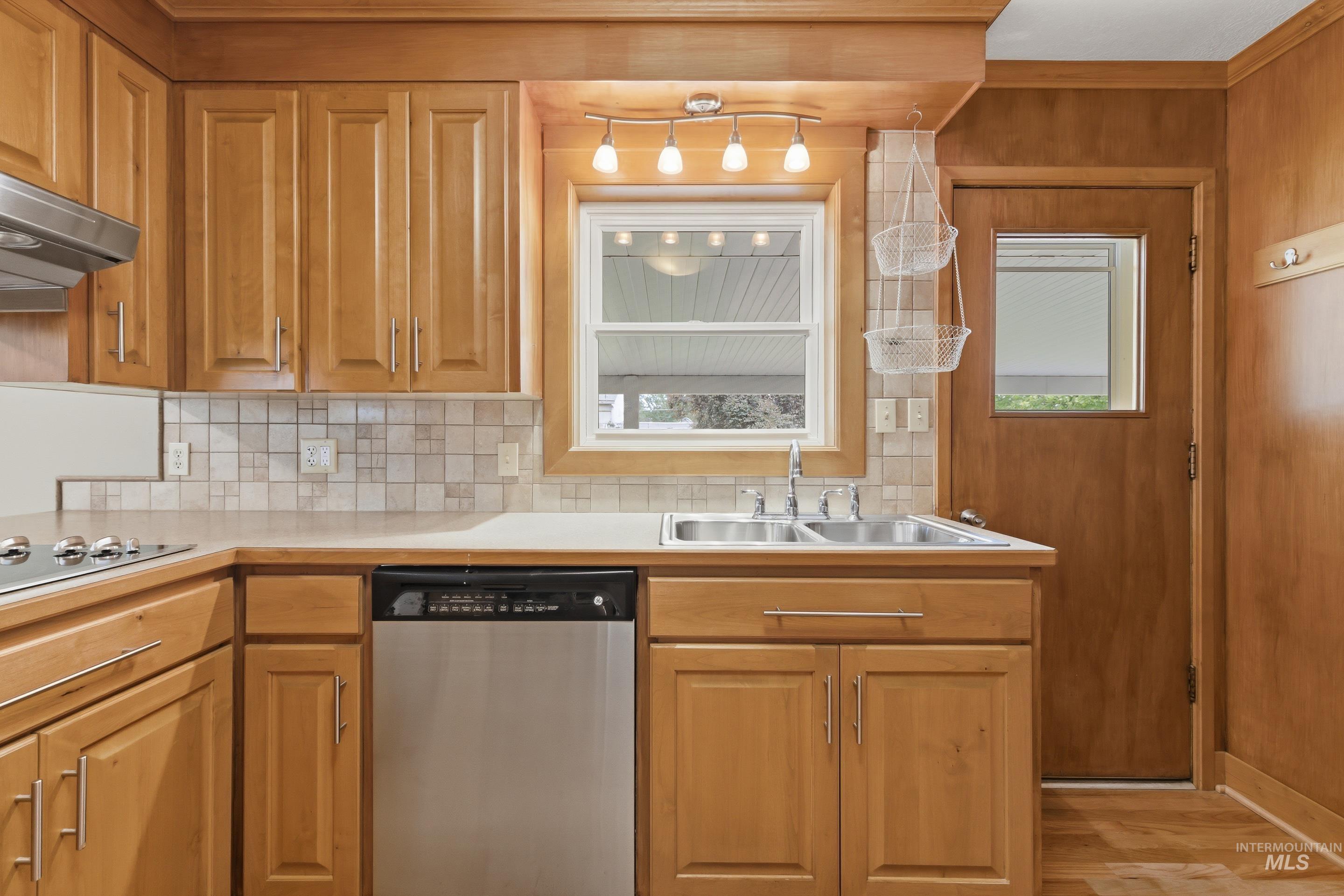 504 West Howe Street Boise, ID 83706 - Photo 19 of 47 Kitchen featuring light wood cabinetry and paneling, a stainless steel dishwasher, and a double basin sink