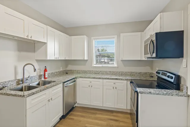 a kitchen with stainless steel appliances granite countertop a sink and a stove top oven