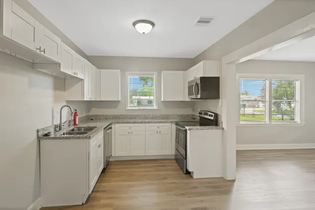 a kitchen with a sink stove top oven and refrigerator