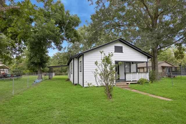 a front view of house with a garden and trees