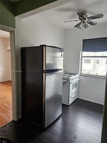 a kitchen with a refrigerator and a ceiling fan