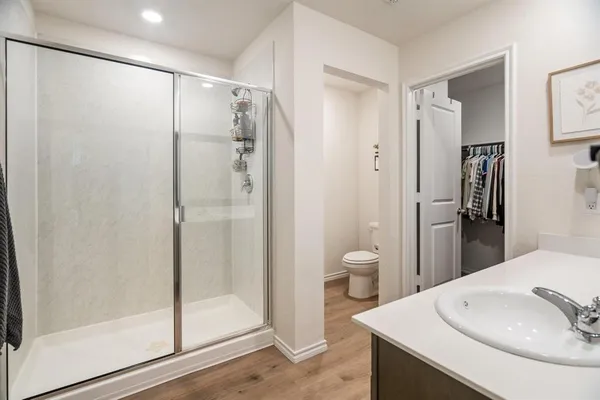 a bathroom with a shower sink vanity and toilet