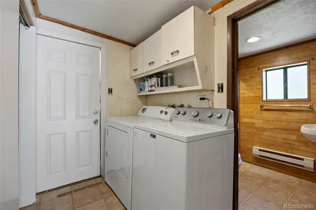 a utility room with cabinets washer and dryer