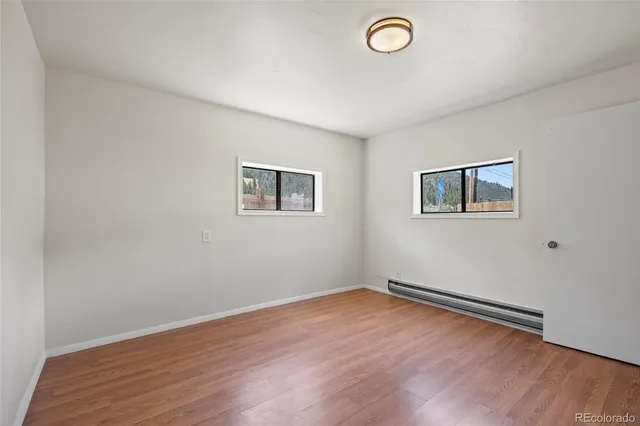 a view of a room with wooden floor and window