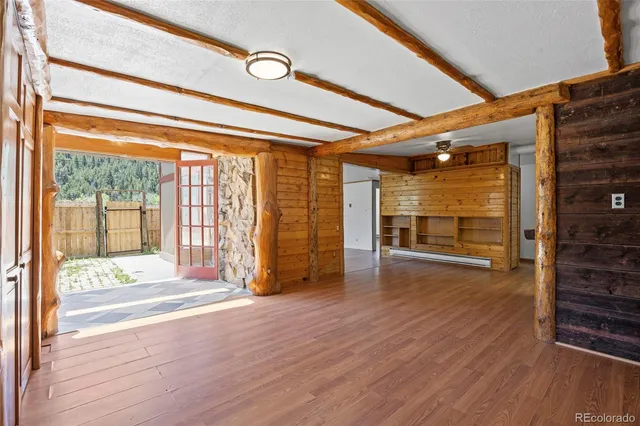 a view of empty room with wooden floor and fan
