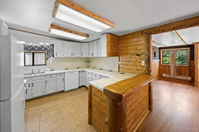 a kitchen with stainless steel appliances granite countertop a sink a stove and a wooden floors