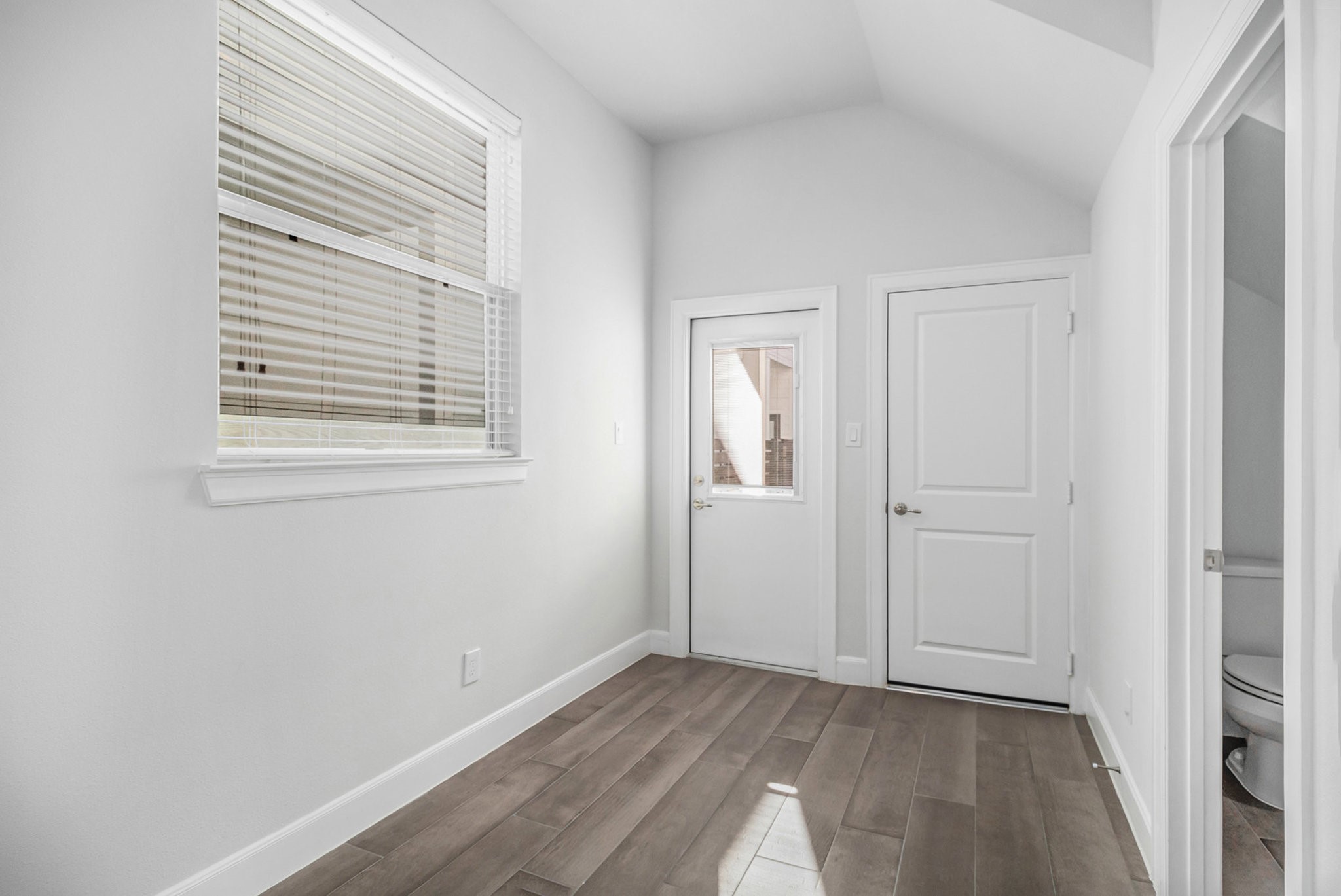9573 Neuens Road, Unit A Houston, TX 77080 - Photo 6 of 22 a view of an empty room with wooden floor and a window