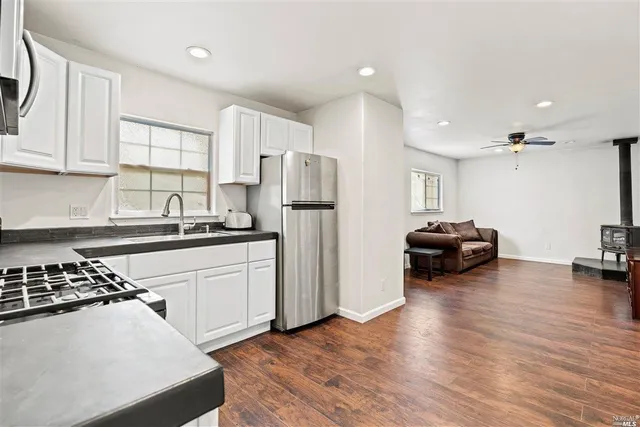 a kitchen with a refrigerator and a stove top oven