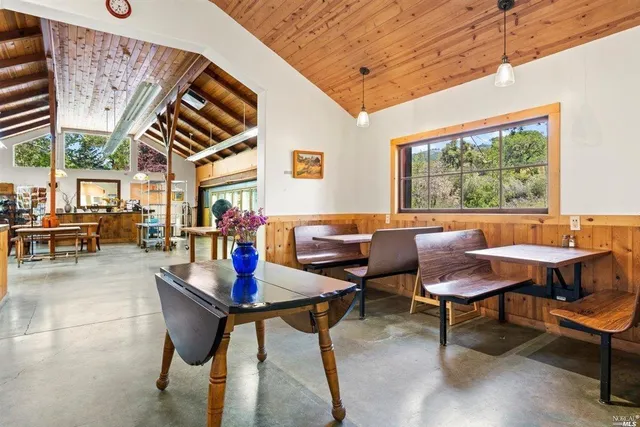 a dining room with furniture a floor to ceiling window and potted plants