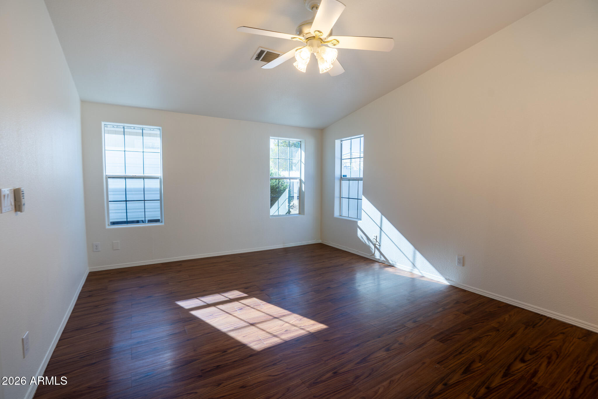 17844 North 17th Place Phoenix, AZ 85022 - Photo 9 of 22 an empty room with wooden floor chandelier fan and windows