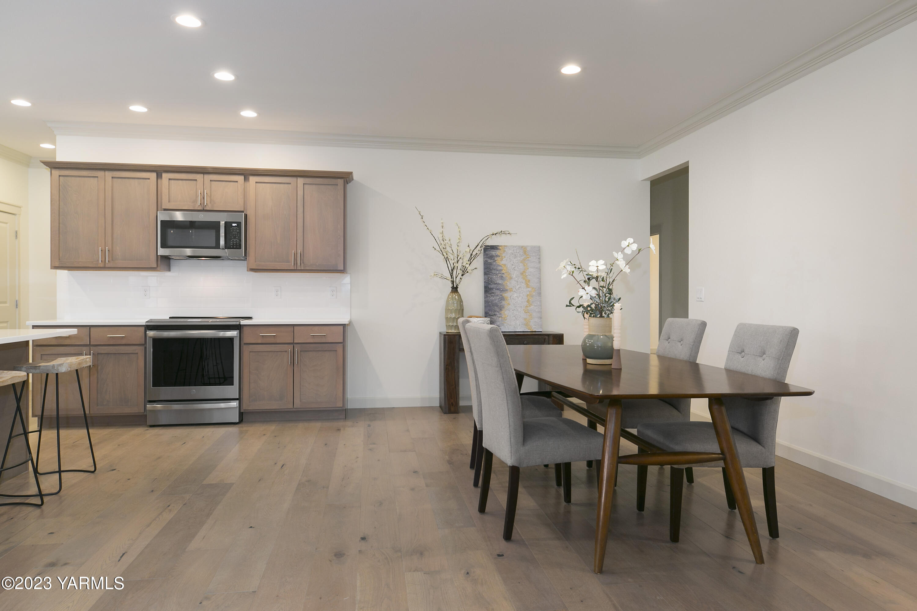 7201 Vista Ridge Avenue Yakima, WA 98903 - Photo 9 of 25 a kitchen with stainless steel appliances kitchen island granite countertop a table chairs sink and cabinets