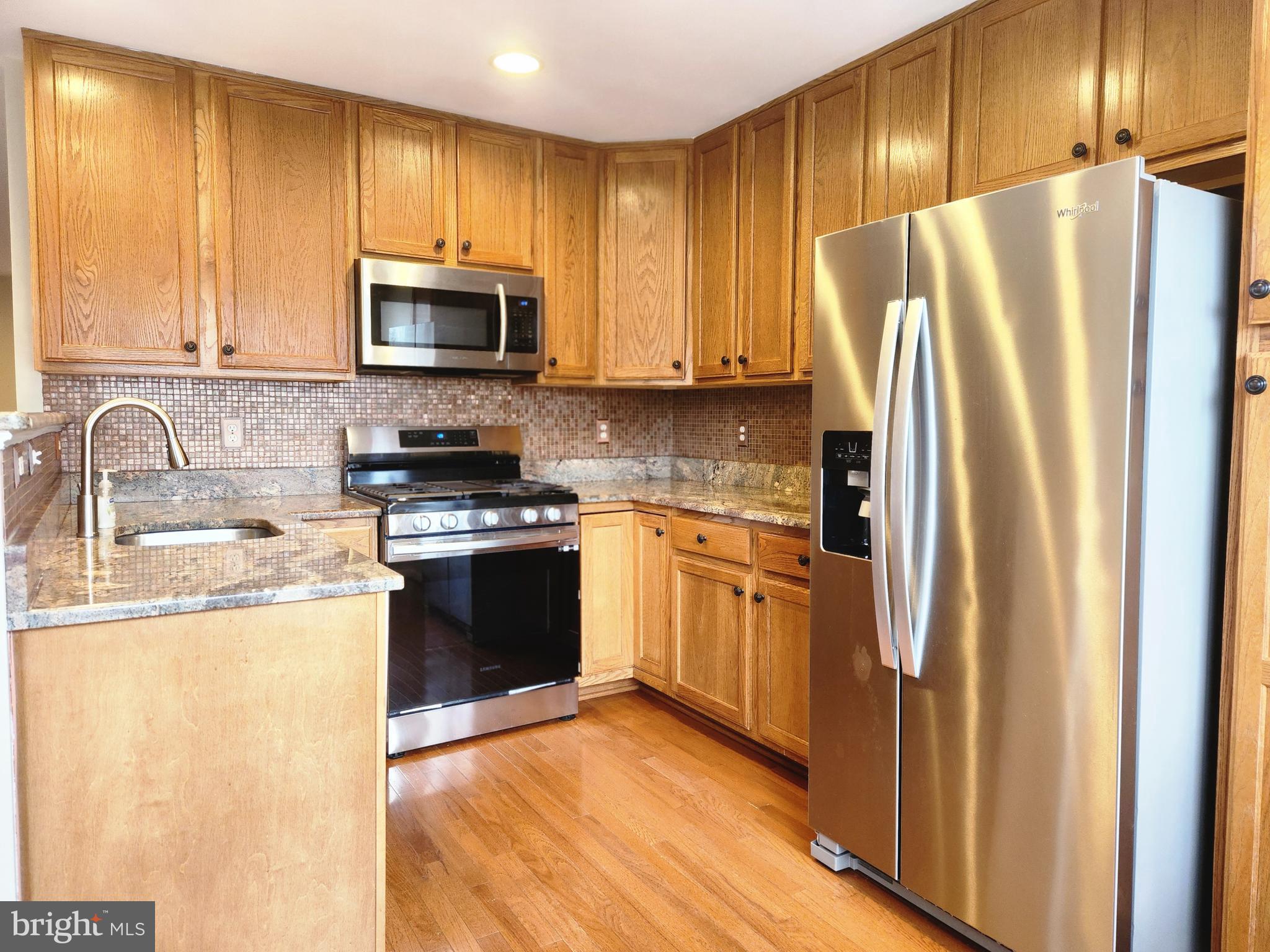 4764 Benecia Lane Dumfries, VA 22025 - Photo 7 of 17 a kitchen with stainless steel appliances granite countertop a refrigerator stove and sink