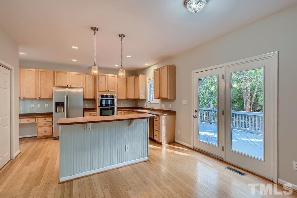 109 Oakbeech Court Holly Springs, NC 27540 - Photo 11 of 28 an open kitchen with wooden floor and stainless steel appliances