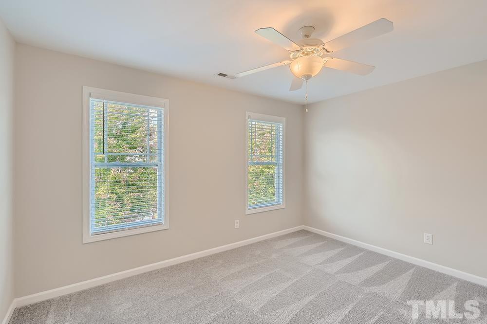 109 Oakbeech Court Holly Springs, NC 27540 - Photo 18 of 28 an empty room with windows and chandelier fan