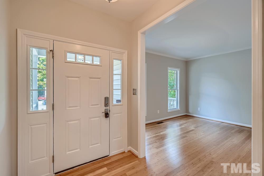109 Oakbeech Court Holly Springs, NC 27540 - Photo 4 of 28 an empty room with wooden floor mirror and windows