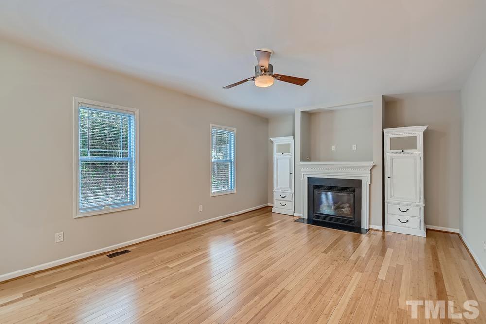 109 Oakbeech Court Holly Springs, NC 27540 - Photo 5 of 28 a view of an empty room with wooden floor fireplace and a window