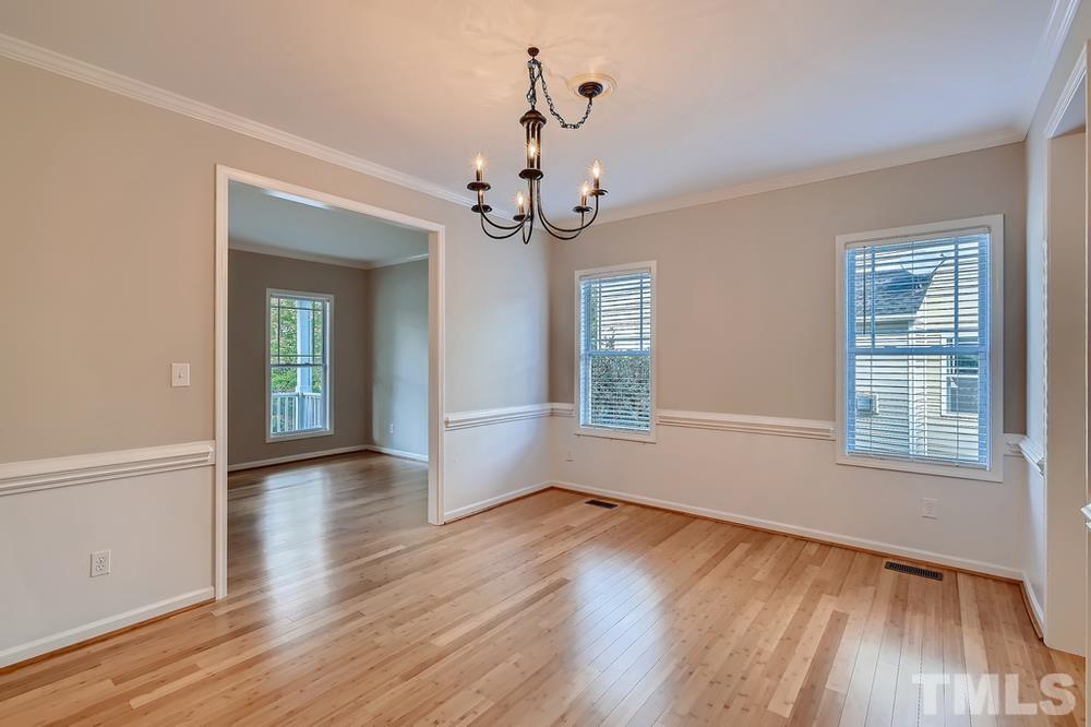 109 Oakbeech Court Holly Springs, NC 27540 - Photo 7 of 28 a view of an empty room with wooden floor and a window