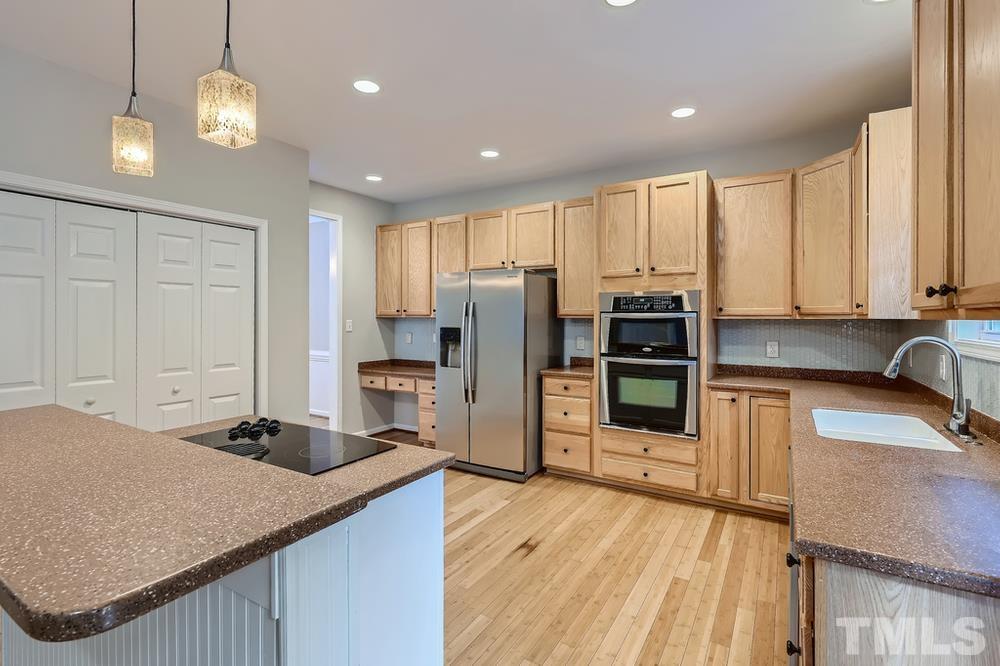 109 Oakbeech Court Holly Springs, NC 27540 - Photo 8 of 28 a kitchen with stainless steel appliances granite countertop a sink refrigerator and cabinets